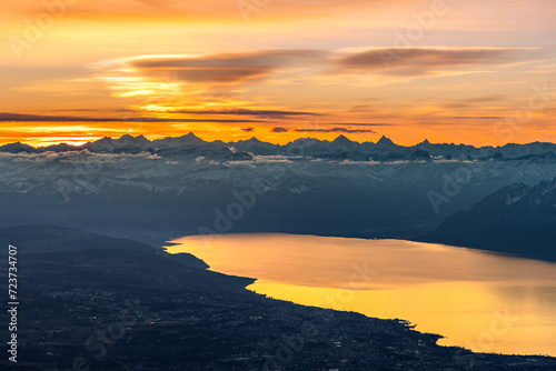 Colourful morning sky with Cirrus clouds above Swiss Alps with lake