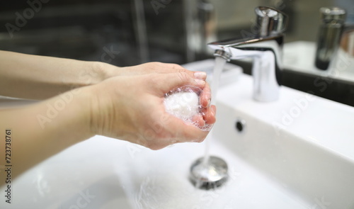 Closeup man washes his hands with soap under tap. Clean hands protect against infection. Global warning to prevent spread coronovirus. Regular disposable hand disinfection during pandemic