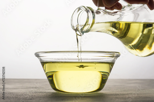 Cooking oil pouring from bottle, Sunflower seed oil, Kitchen preparing, helianthus annuus photo