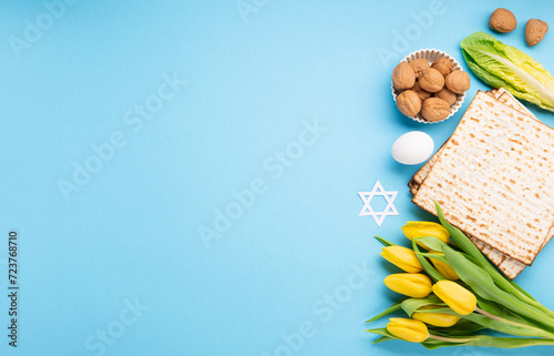 Passover Greeting Card with Matzah, Waluts and Yellow Tulip Flowers on Blue Background. photo