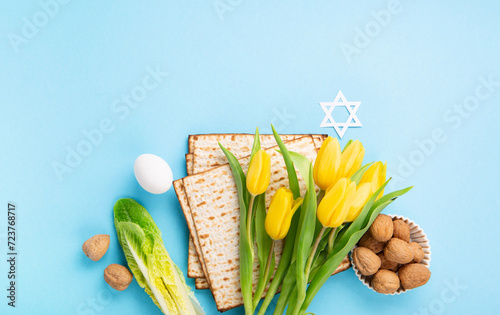 Fototapeta Naklejka Na Ścianę i Meble -  Passover Greeting Card with Matzah, Waluts and Yellow Tulip Flowers on Blue Background.