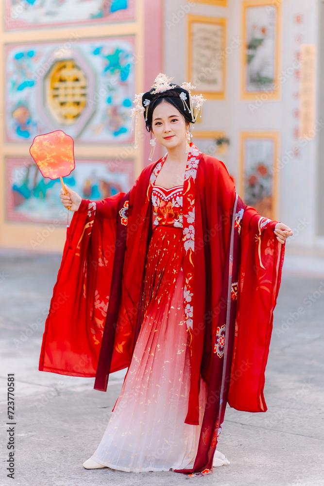 Fototapeta premium Woman dress China New year. portrait of a woman. person in traditional costume. woman in traditional costume. Beautiful young woman in a bright red dress and a crown of Chinese Queen posing.