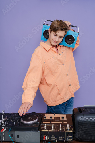 Cool charming boy hold boom box on his shoulder want listen vintage music isolated over bright color background