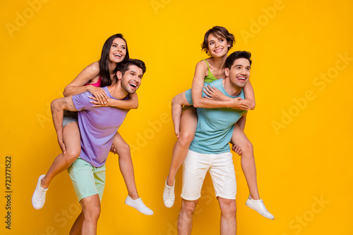 Photo of four people have free time look on ads guy piggyback girls isolated shine color background
