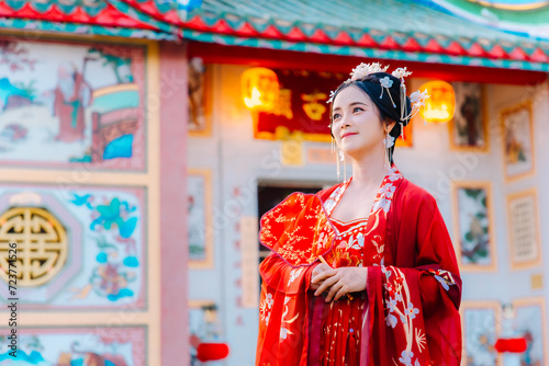 Woman dress China New year. portrait of a woman. person in traditional costume. woman in traditional costume. Beautiful young woman in a bright red dress and a crown of Chinese Queen posing. © Tanarat