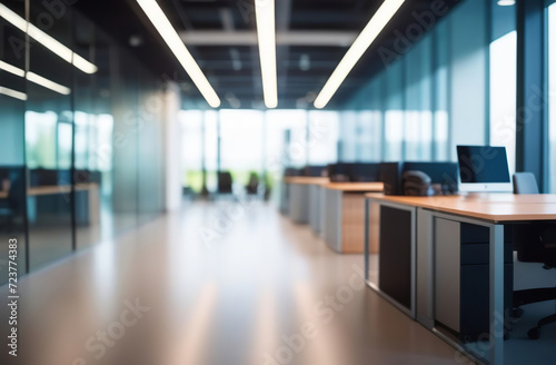 Blurred empty modern office. Defocused abstract light bokeh business open space interior background for design. Corporate strategy  finance  operations  marketing. Blur focus of tables with computers