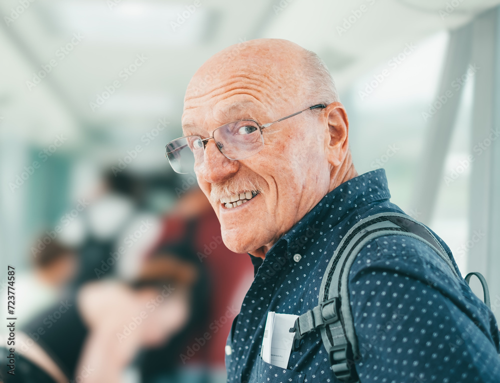 Portrait of happy bald senior male traveler queuing for boarding on plane, tourism and vacation concept Portrait of happy bald senior male traveler queuing for boarding on plane, tourism and vacation concept