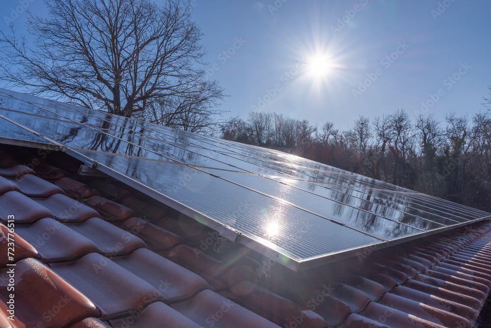 Solarmodule auf einem Hausdach reflektieren die Winter Sonne vor einem klaren blauen Himmel, Oberfranken, Deutschland - obrazy, fototapety, plakaty 