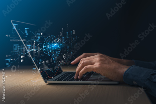 Businessman using laptop with digital screen about brain of AI and exponential graph. Digital information technology and artificial intelligence concept. photo
