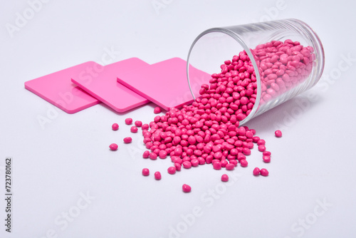 Φωτογραφία pink masterbatch granules with color chips as an example of the color produced,