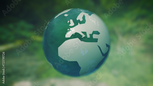 Three-dimensional earth globe made of glass rotates in front of green natural eco background
