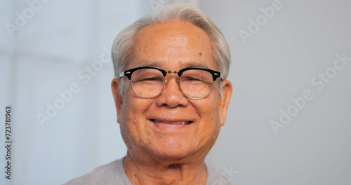 Close up, portrait of older man smiling and looking at the camera © ronnarong