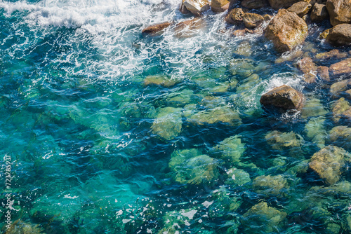 Fototapeta Naklejka Na Ścianę i Meble -  Landscape with transparent Mediterranean sea water with rocks underwater and foam, ITALY