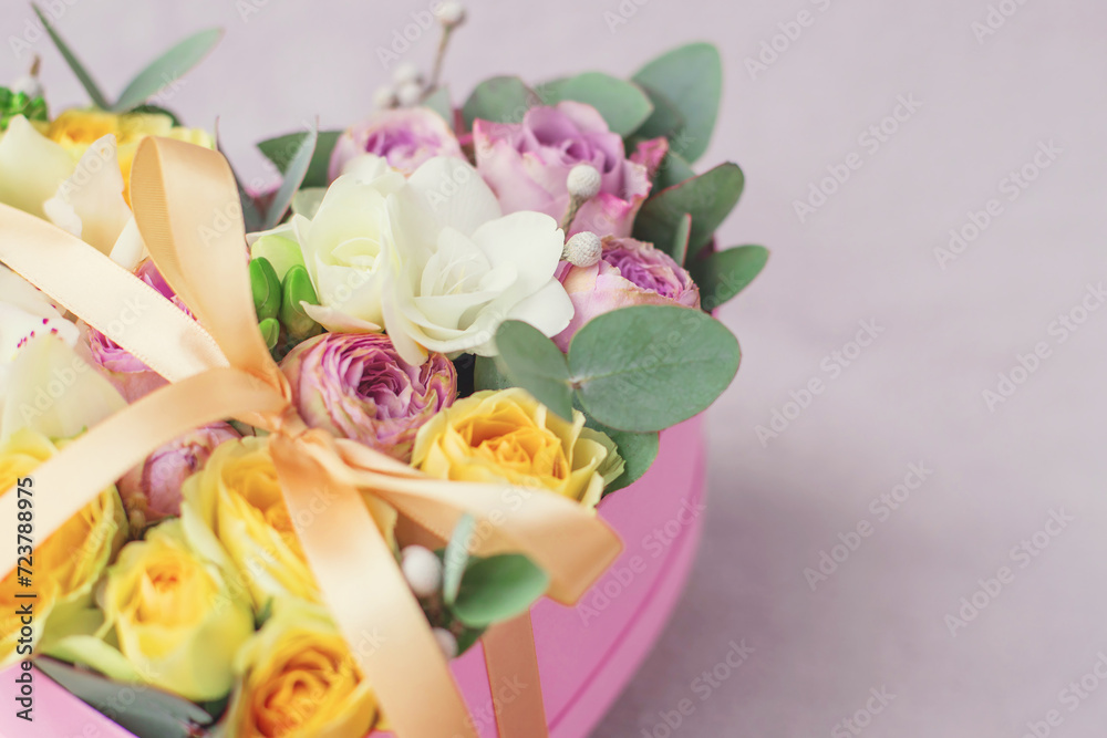 Pink flowers in a pink heart box. White orchid, purple and yellow roses with bunch. Womans day . Flowers bouquet on background . Romantic concept. Copy space Pink flowers in a pink heart box. White orchid, purple and yellow roses with bunch. Womans day . Flowers bouquet on background . Romantic concept. Copy space