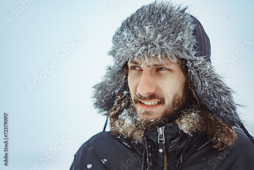 a bearded man in an earflap in winter