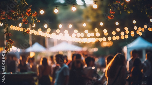 Blurred image of street food festival with bokeh lights .