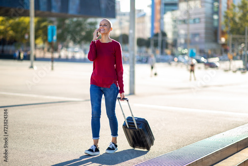 travel woman with mobile phone and suitcase in city