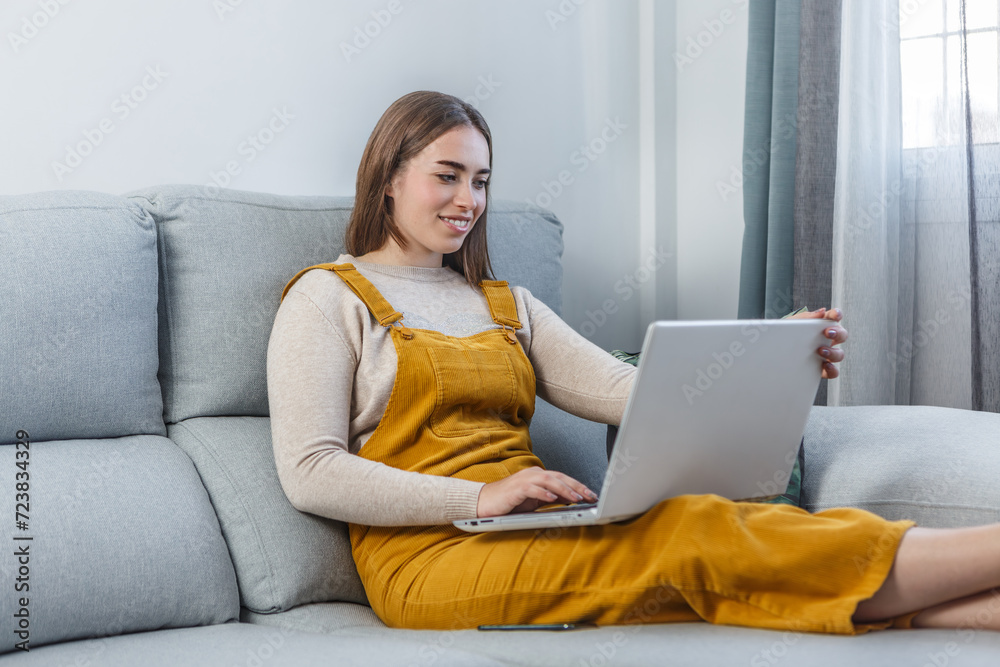 Woman Sitting on Couch Using Laptop Computer for Work Woman Sitting on Couch Using Laptop Computer for Work