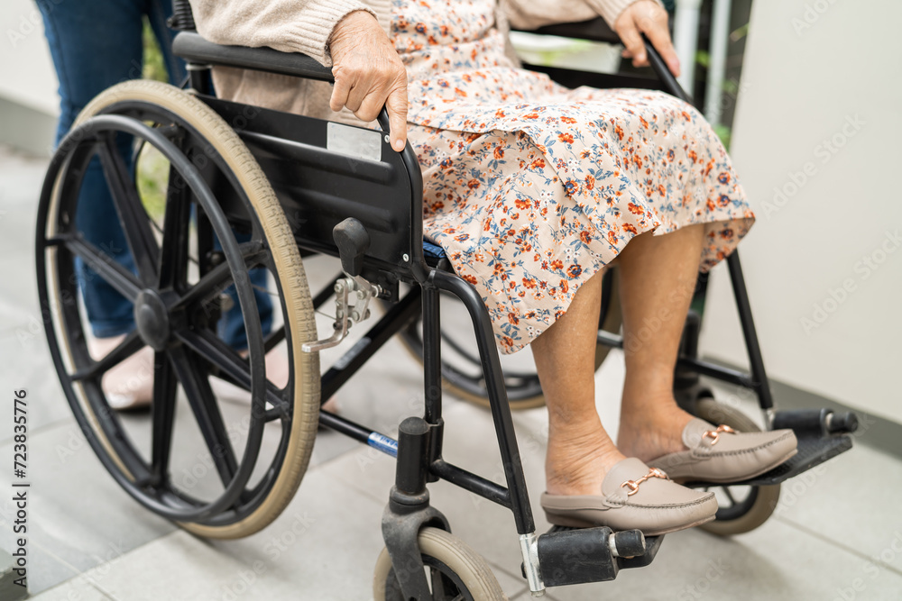 Obraz premium Caregiver help and care Asian senior woman patient sitting on wheelchair to ramp in nursing hospital, healthy strong medical.
