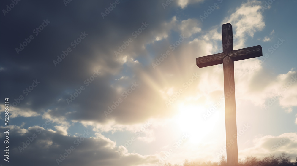 Catholic easter. Christian wooden cross against blue  sky with clouds and sun rays. Silhouette in sunrise. Concept of  Jesus resurrection day