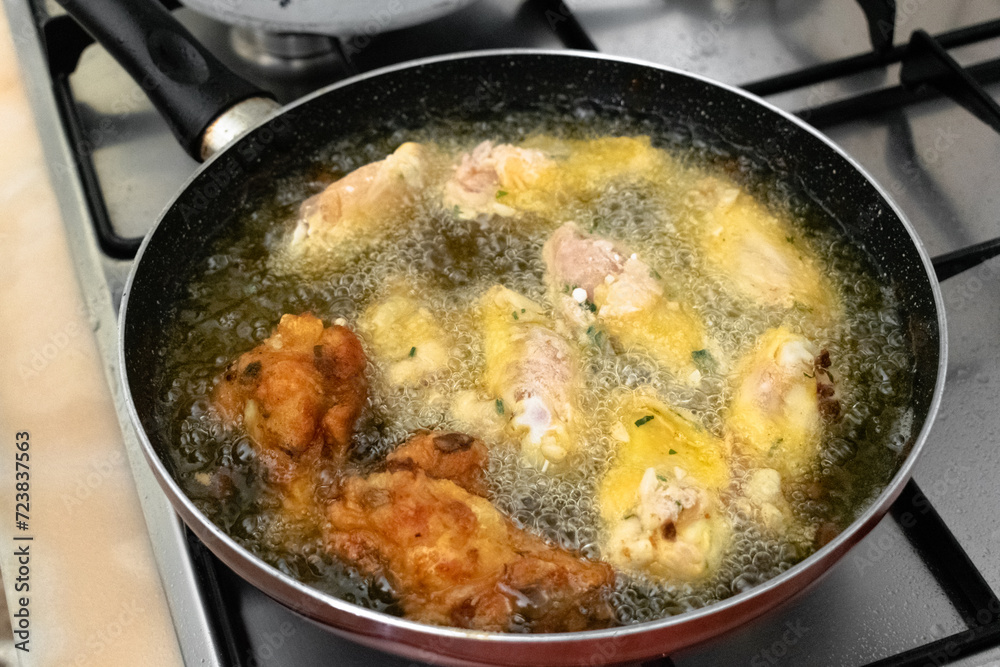 Frying chicken wings in hot vegetable palm oil in the pan Frying chicken wings in hot vegetable palm oil in the pan