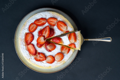 Still life with homemade japanese fluffy cheesecake arranged with fresh strawberries on a dark background