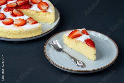Still life with homemade japanese fluffy cheesecake arranged with fresh strawberries on a dark background