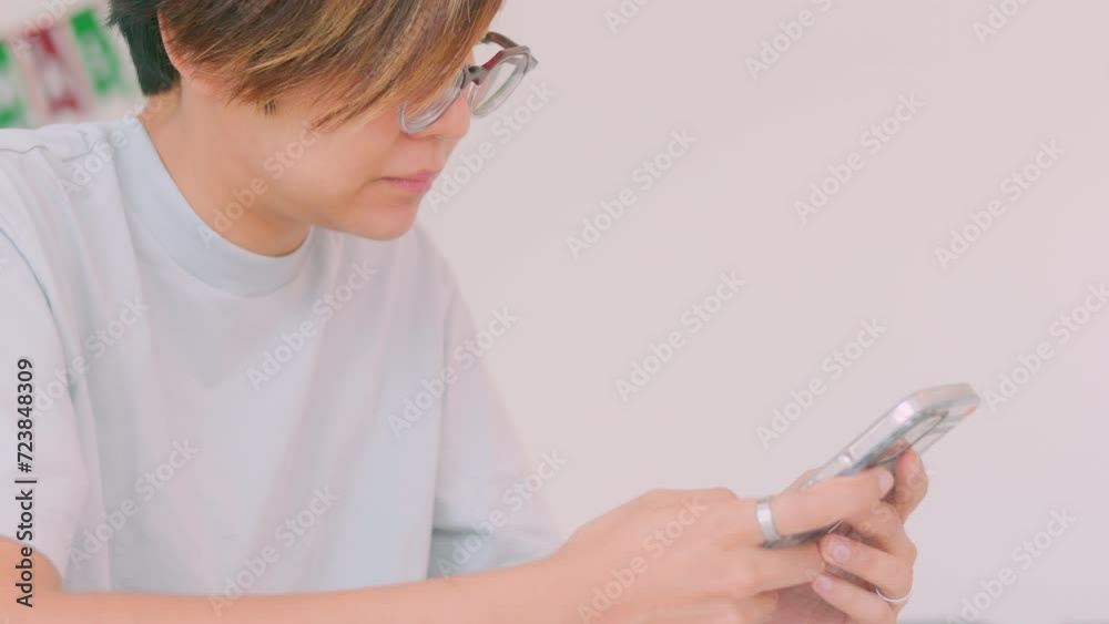 Close up face of pretty Asian woman who is using smartphone for online shopping, social networking and connecting people via digital technology as urban lifestyle with happiness and enjoyment. Close up face of pretty Asian woman who is using smartphone for online shopping, social networking and connecting people via digital technology as urban lifestyle with happiness and enjoyment.