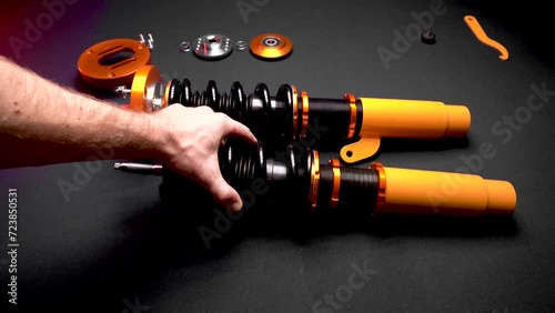 tuning car suspension, coilovers, shock absorbers and front springs in yellow and gold color for a sports drift car on a dark background assembly by the hands of a car mechanic photo