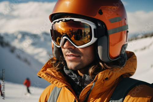 Skier in orange jacket, helmet and goggles. Head shot . Winter sport concept