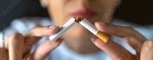 Woman breaking a cigarette in half. Stop smoking concept. photo