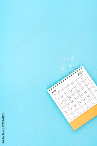 Desk calendar for May 2024 and white paper clip on a light blue background