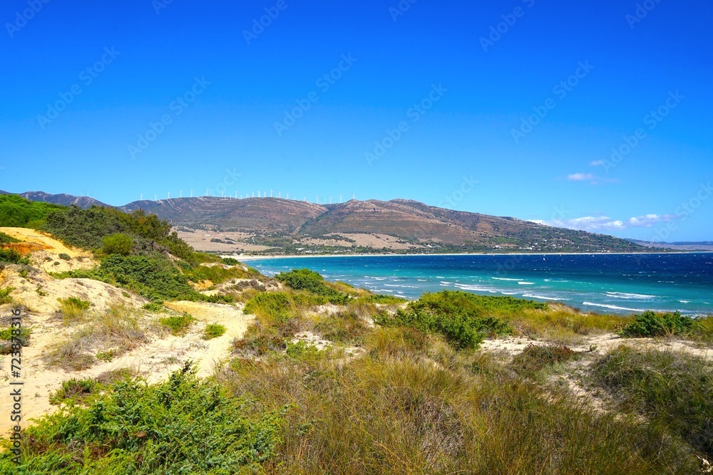 view of the beautiful coastline at the Punta Paloma beach with dunes and mountains near Valdevaqueros, Tarifa, Andalusia, province of Cádiz, Spain
