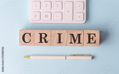 CRIME on wooden cubes with pen and calculator, financial concept photo