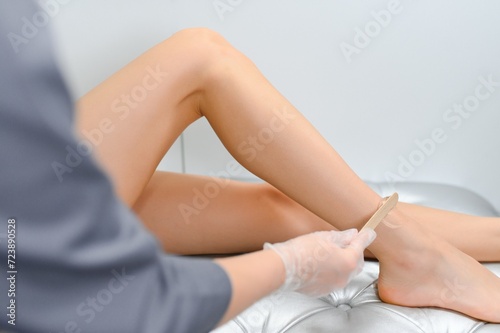 close-up of young caucasian slender woman getting laser epilation in beauty salon.