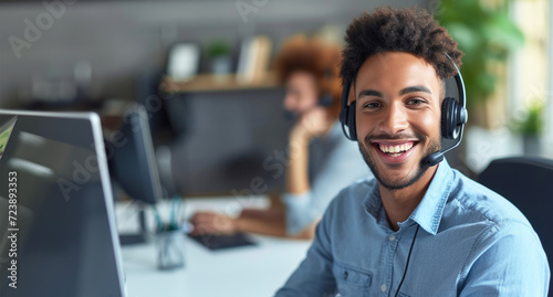 Happy young male customer support executive working in office. Theyve got the answers youre looking for. Cropped shot of a handsome young man working in a call center with a colleague  photo
