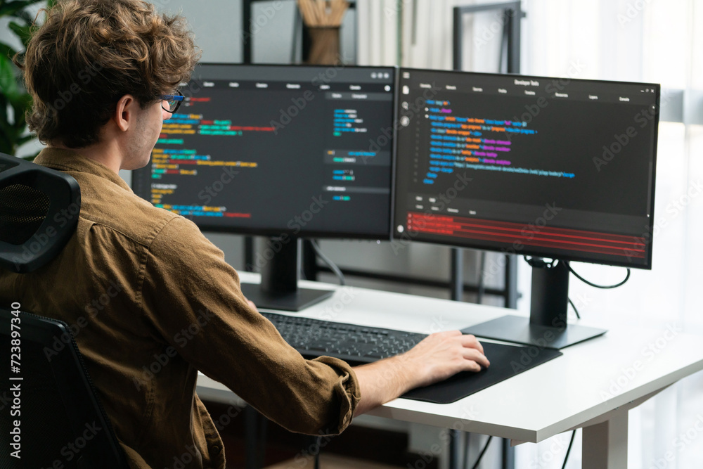 IT developer working online software development on pc monitors at ...