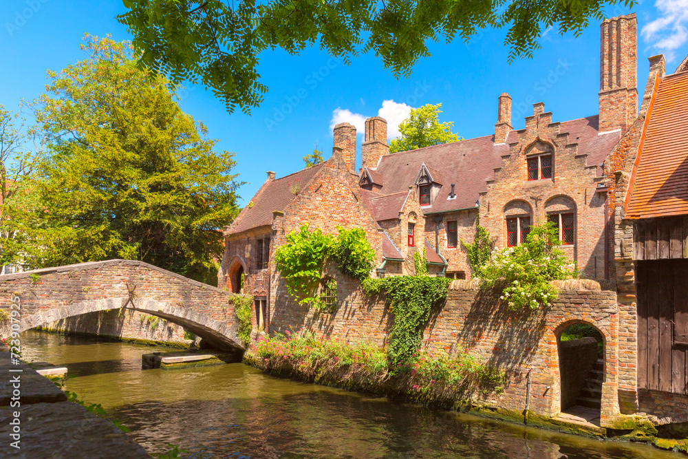 Obraz premium Quaint stone pedestrian Boniface Bridge with romantic view of canal and town, Bruges, Belgium