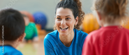 A physical education teacher shares a joyful moment with young students during a gym class