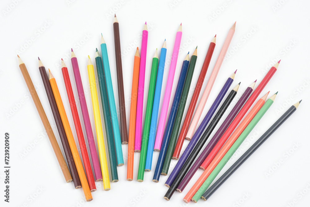 Collection of seamless coloured pencils lying loose and placed in a row facing up on white background