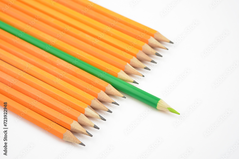 Fototapeta premium Concepts of choice or leadership. Think differently. Sustainability. With wooden pencils and focus on green. Photographed on white background