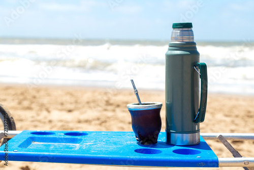 Yerba mate infusion typical of South America. Pumpkin Mate accompanied by the thermos on the beach.