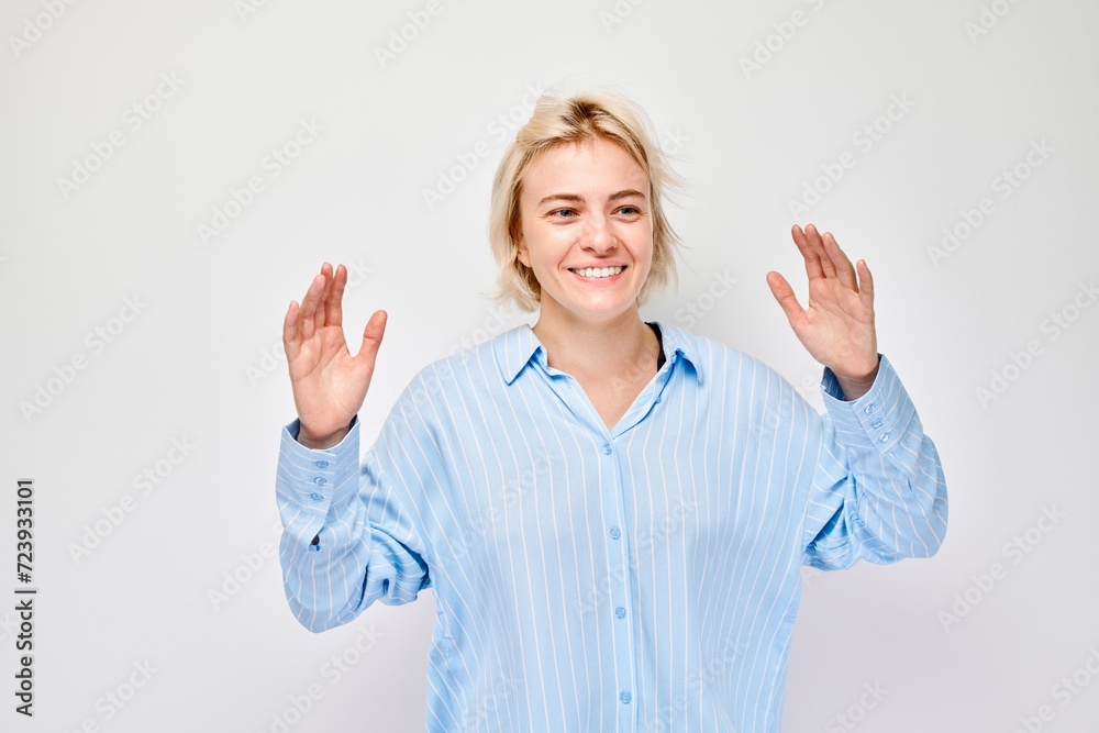 Portrait blond young woman happy face smiling joyfully with raised palms and shocked open mouth isolated on white studio background. Portrait blond young woman happy face smiling joyfully with raised palms and shocked open mouth isolated on white studio background.