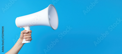 Un mégaphone blanc sur fond bleu, image avec espace pour texte. photo