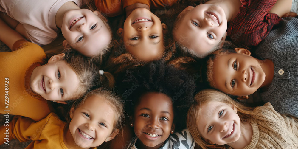 Portrait of cheerful multiracial kids looking into camera and smiling. Children of different skin color, top down view.