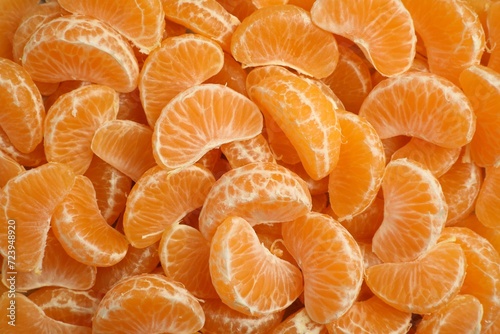 Delicious tangerine segments as background, top view
