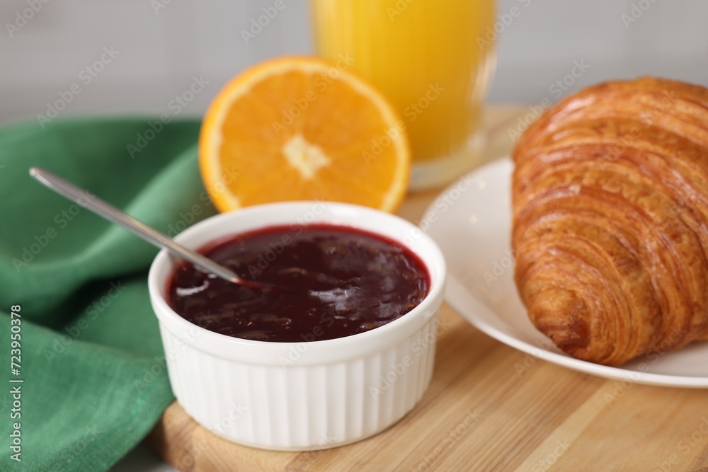 Breakfast time. Fresh croissant and jam on wooden board, closeup Breakfast time. Fresh croissant and jam on wooden board, closeup