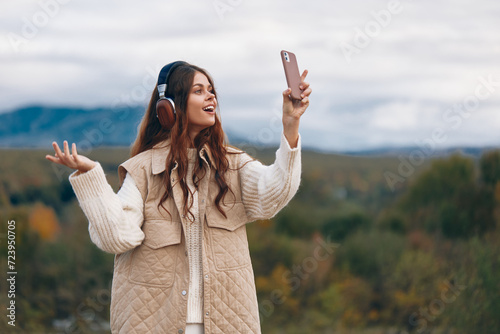 Mountain Woman: Embracing Freedom and Nature, Smiling Adventurous Traveler Takes a Selfie with Phone in Stunning Landscape