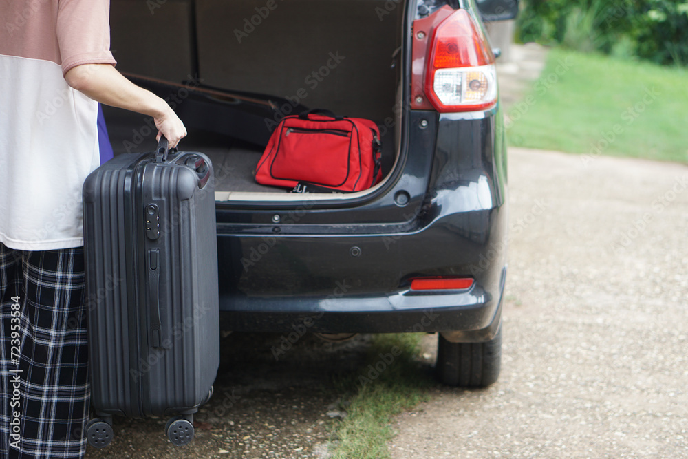 Close up man is carrying suitcases, luggage into car trunk for a journey. Concept, travelling, going by car. Vacation, holiday or weekend trip. Prepare and ready go. Close up man is carrying suitcases, luggage into car trunk for a journey. Concept, travelling, going by car. Vacation, holiday or weekend trip. Prepare and ready go.