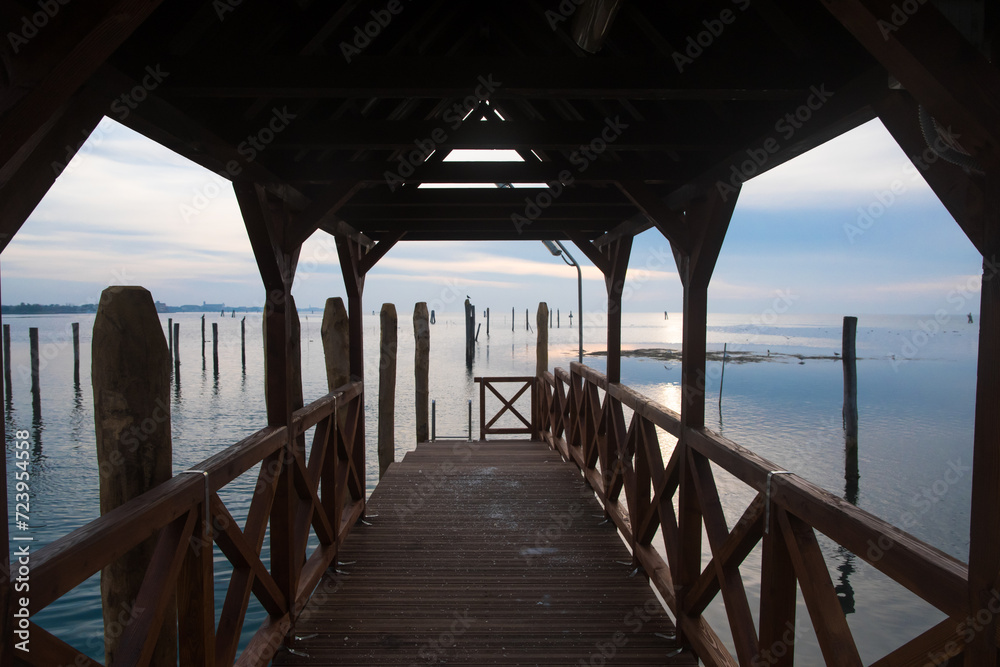 Le luci del tramonto viste dall'interno di un molo di legno dell'isola di Pellestrina nella laguna di Venezia